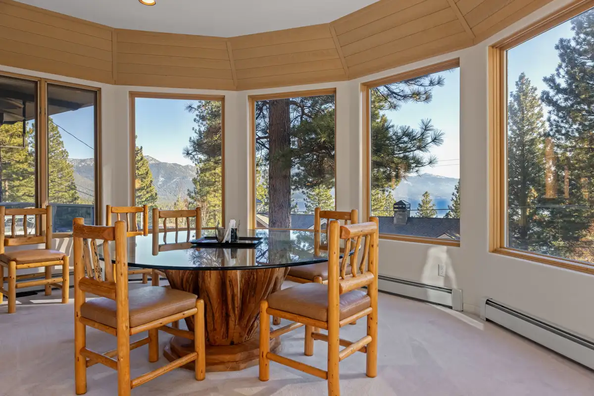 Dining table in a window-lined nook with mountain view, 90s Tahoe Time Capsule