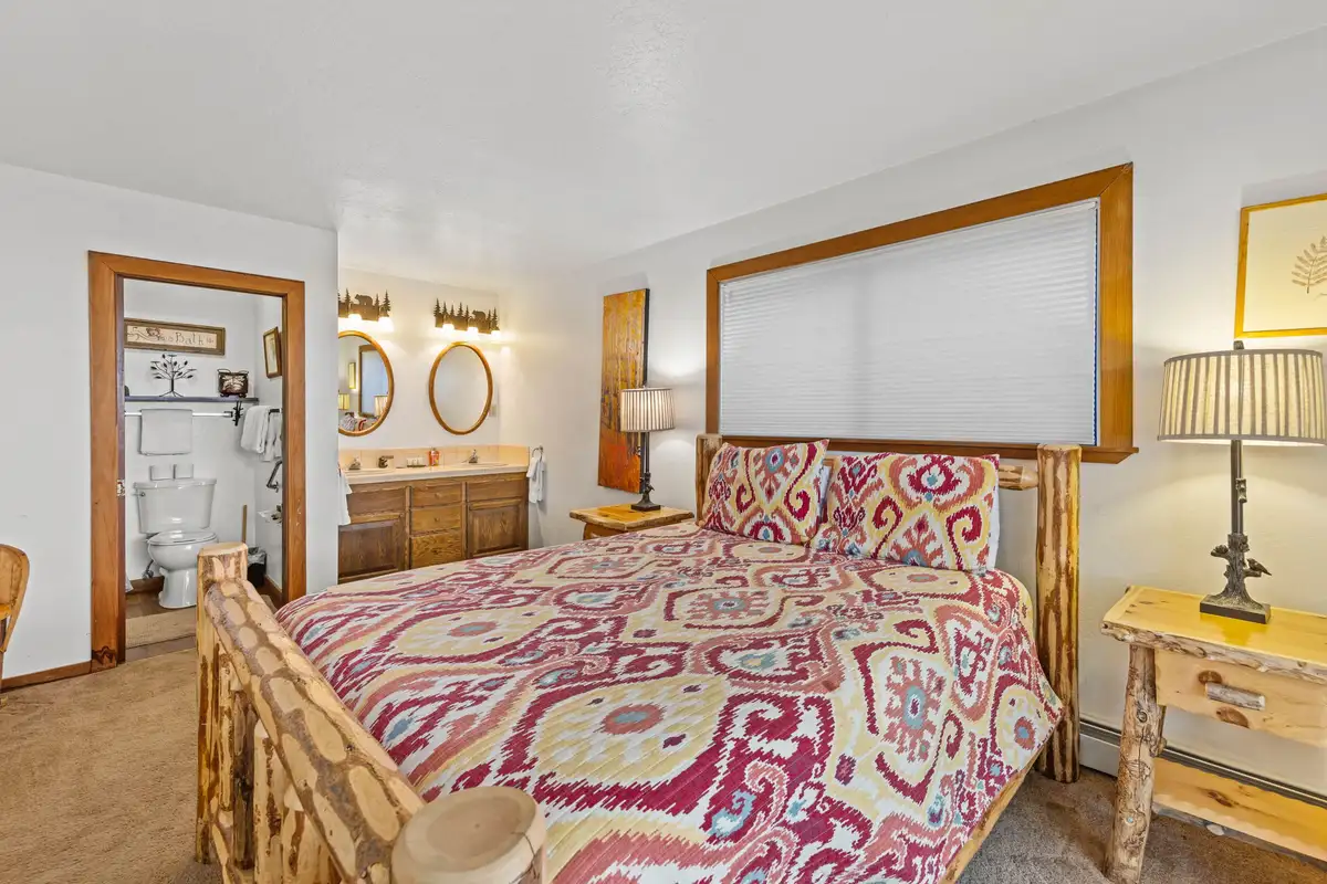 Bedroom with a log bed frame and patterned bedding, Rustic Ridge Retreat