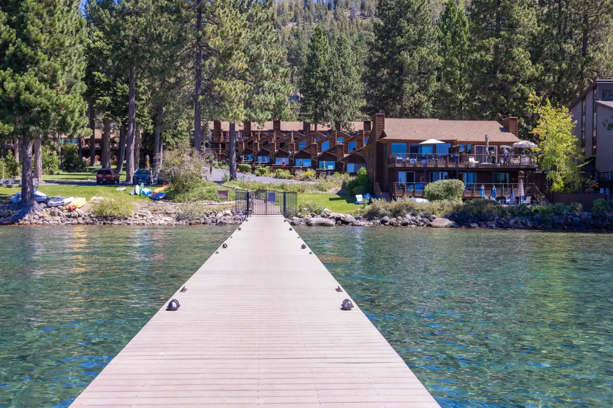 Pier leading back to lakeside buildings among pines, Lakeside Luxe Retreat