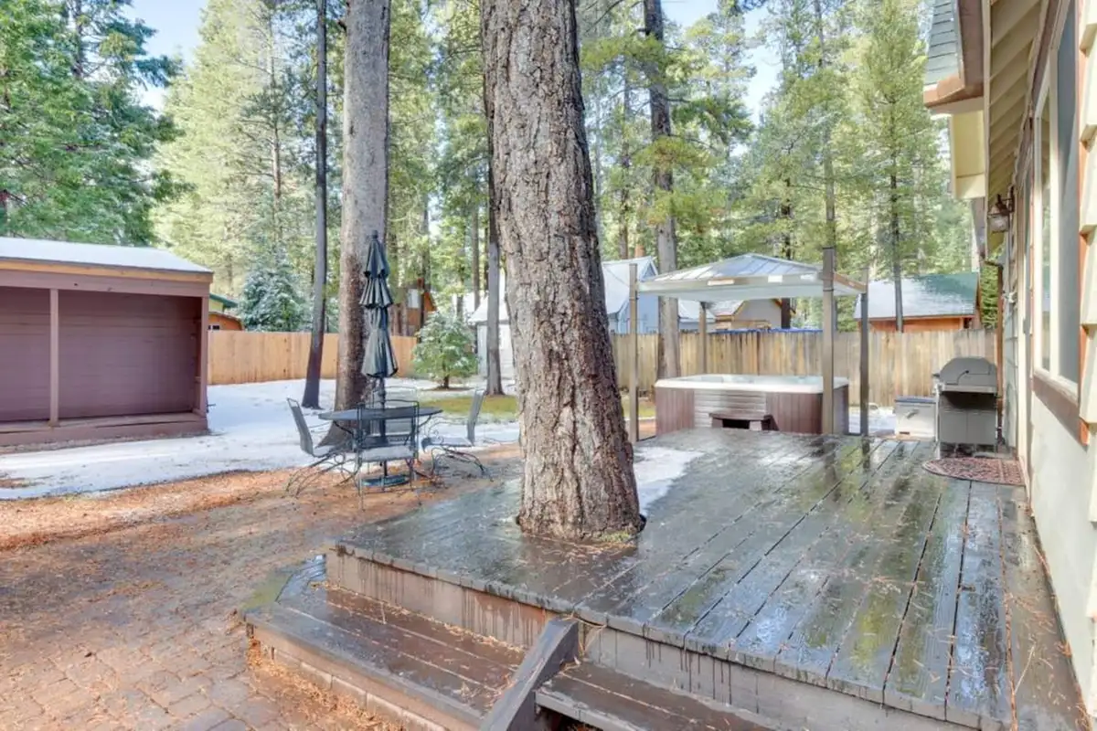 Deck built around a tree with patio table and hot tub, Tranquil Trails Cabin