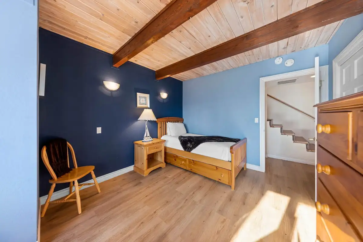 Blue bedroom with a twin bed and beamed wood ceiling, Tranquil Alpine Bliss