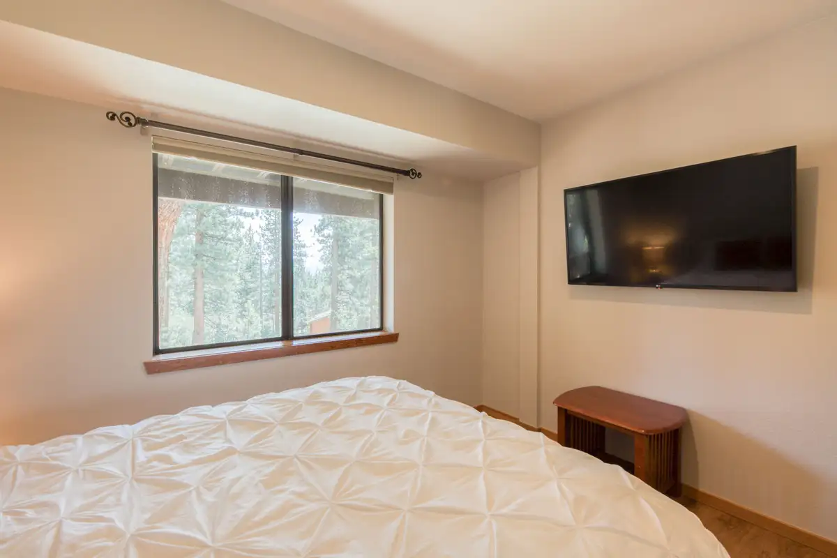 Bedroom with a white bed and wall-mounted TV, Lunar Lakeview Haven