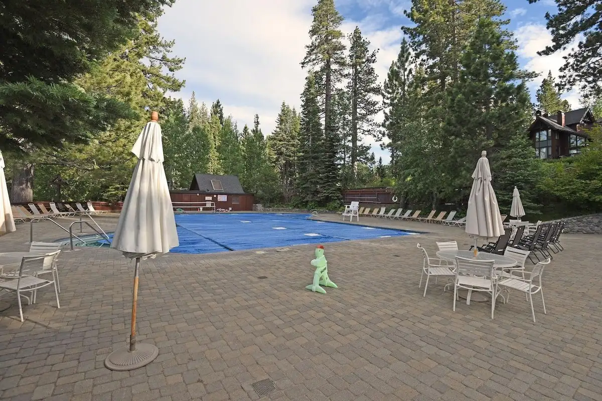 Community pool area with umbrellas and lounge chairs, Enchanting Chamberlands Cabin