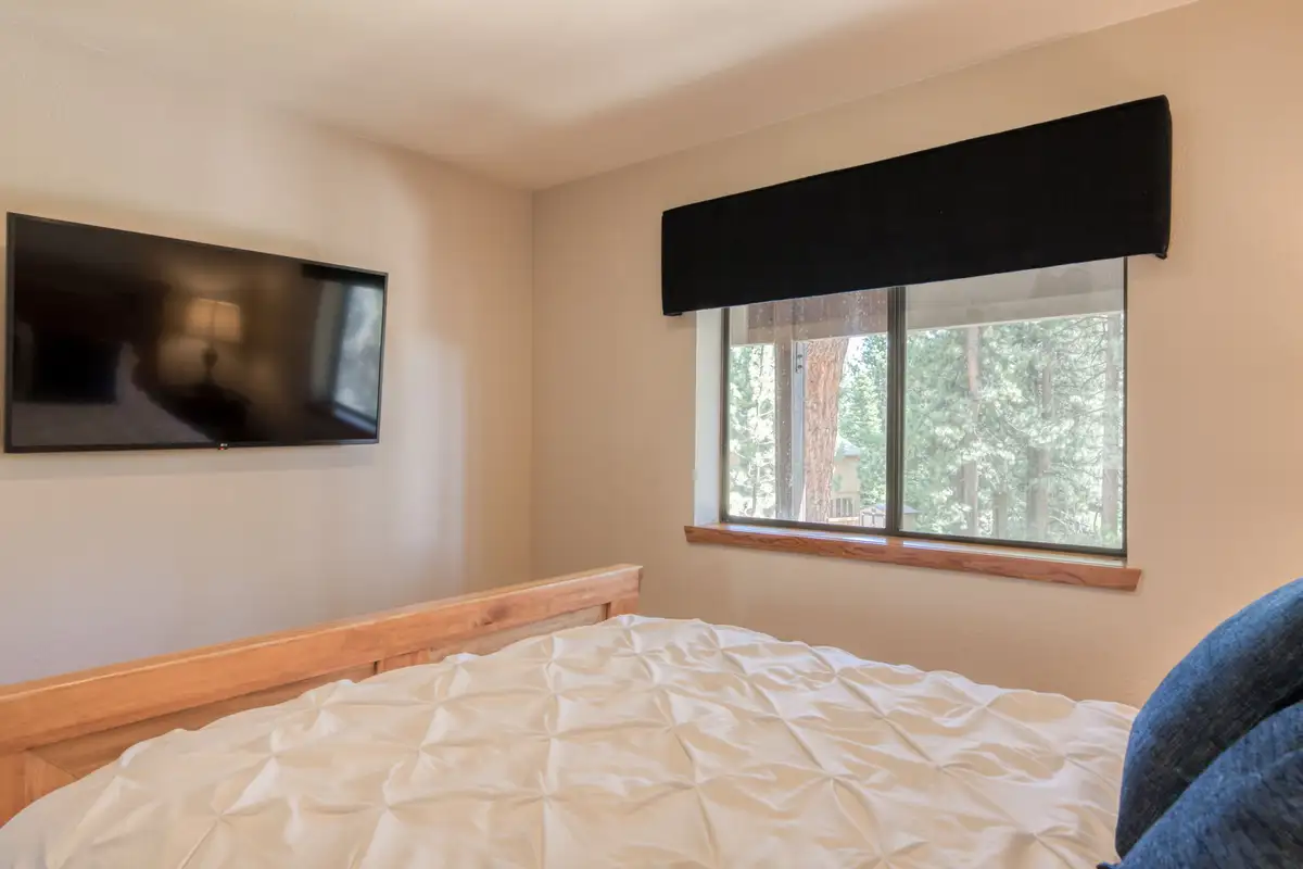 Bedroom with a wood bed frame and wall-mounted TV, Lunar Lakeview Haven