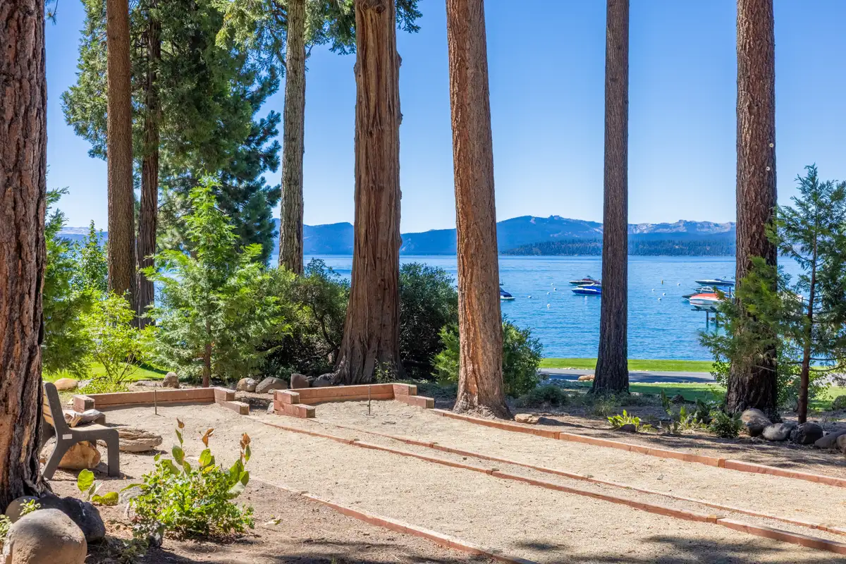 Bocce court and lawn with Lake Tahoe beyond the trees, Lakeside Luxe Retreat