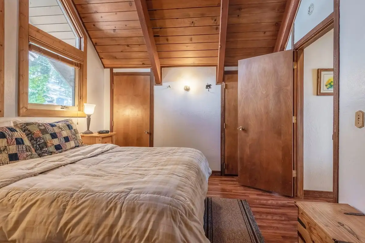 Bedroom with a bed under a sloped wood ceiling, Lakeview Serenity Cottage