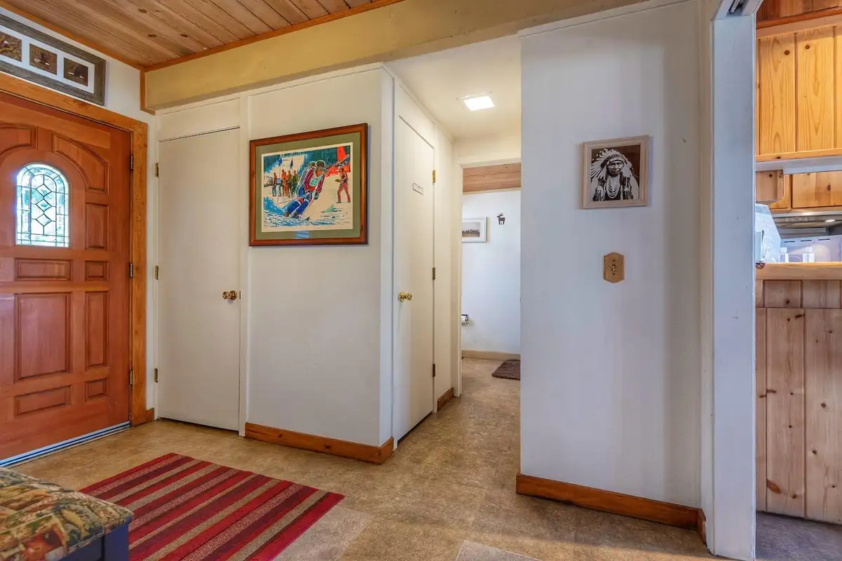 Entryway with a wood front door and striped rug, Lakeview Serenity Cottage