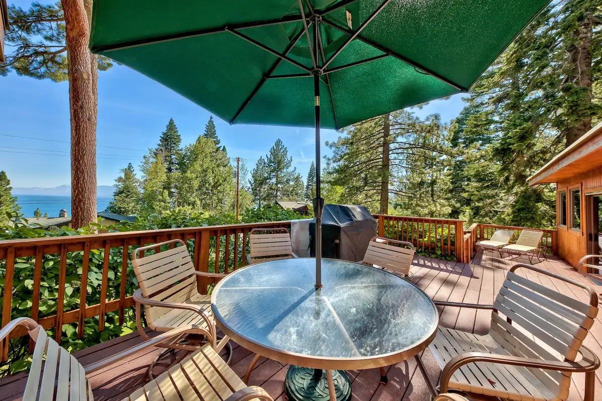 Deck dining table with Lake Tahoe visible beyond the trees, Mammoth Haven Retreat