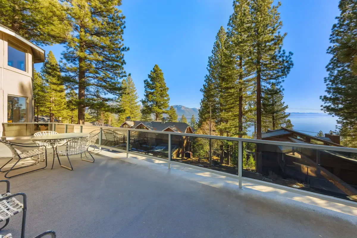 Large deck with table and Lake Tahoe visible beyond the trees, 90s Tahoe Time Capsule