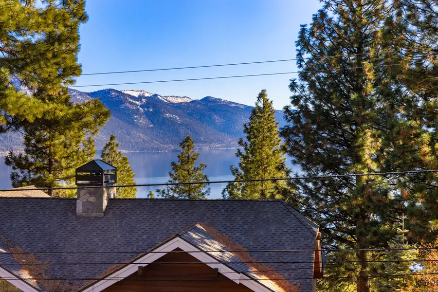 Lake Tahoe and mountains seen over rooftops and pines, 90s Tahoe Time Capsule