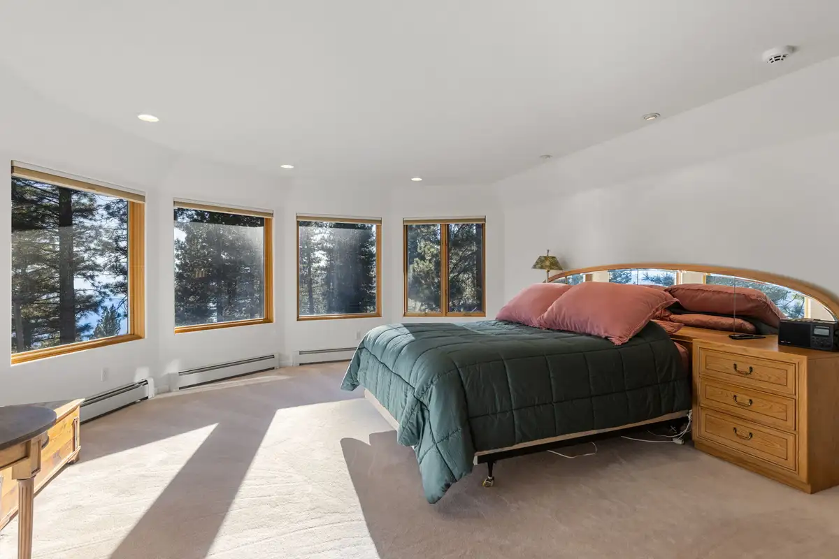 Bedroom with a bed and a curve of windows, 90s Tahoe Time Capsule