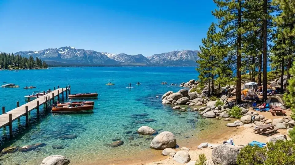Clear water, boulders and a pier on a Lake Tahoe beach